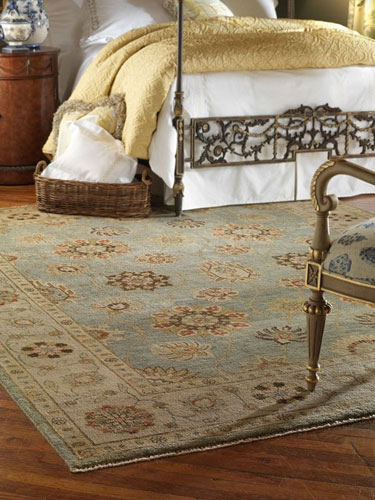 vintage rug placed on top of a wooden floor in a bedroom