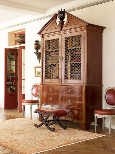 vintage area rug placed in front of a cabinet with a stool on top