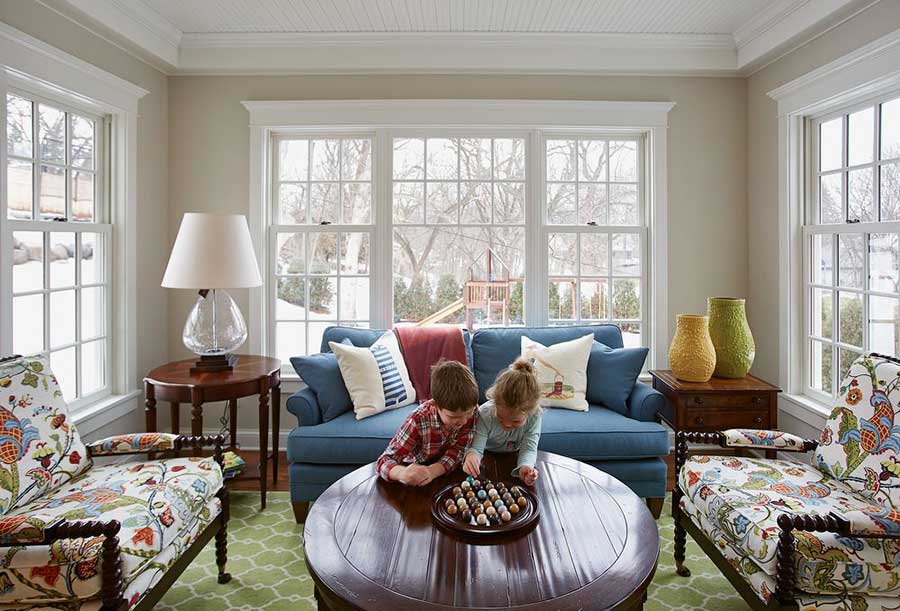 two kids side-by-side in a cape cod-inspired room