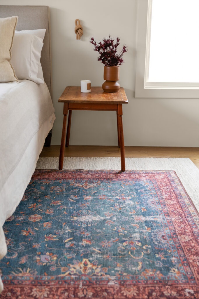 small wooden table on one side of an area rug