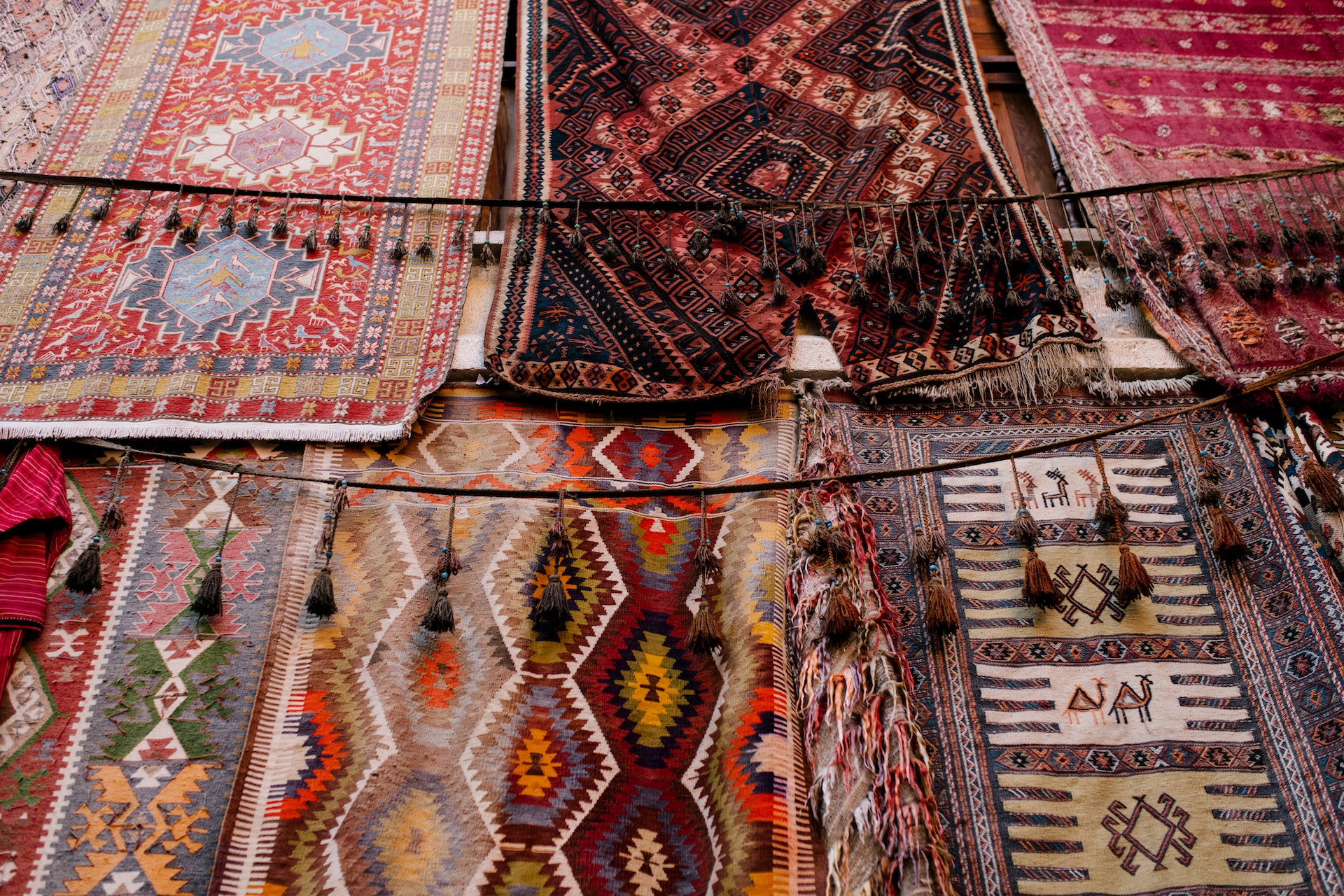 woven Persian rugs in an open market.